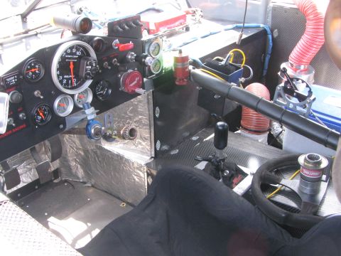 1996 Ford C-350 (Centurion Conversions) - The dashboard of a race car is filled with gauges and switches, with a prominent tachometer and steering wheel.