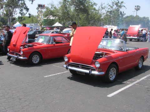 1996 Ford C-350 (Centurion Conversions) - Two red sports cars with hoods open at an outdoor event.