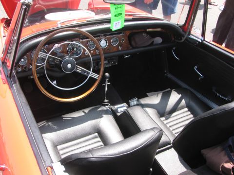 1996 Ford C-350 (Centurion Conversions) - Interior view of a vintage red convertible, showing the dashboard, seats, and steering wheel.