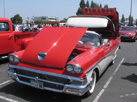 1996 Ford C-350 (Centurion Conversions) - A two-tone red and white convertible, likely a 1958 model, is parked with its hood open at an outdoor event.