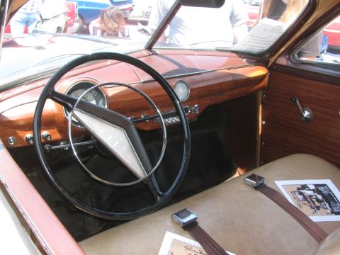1996 Ford C-350 (Centurion Conversions) - The interior of a vintage car features a wood-paneled dashboard and a large steering wheel, with other vehicles visible through the windshi…