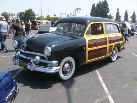 1996 Ford C-350 (Centurion Conversions) - Black 1950 Ford Woody Wagon parked at an outdoor event.