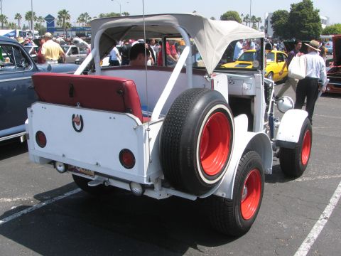 1996 Ford C-350 (Centurion Conversions) - A white custom convertible with a red interior and red wheels is parked at an outdoor event.