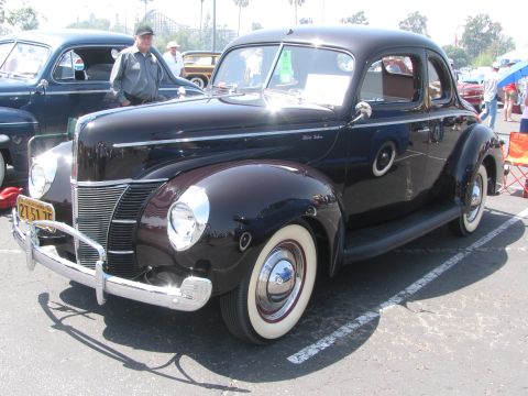 1996 Ford C-350 (Centurion Conversions) - A dark-colored 1939 Ford Coupe is parked at an outdoor event.