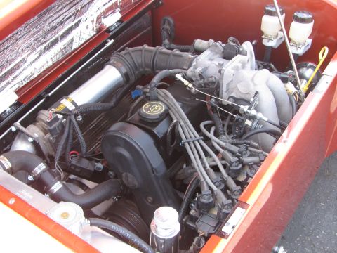 1996 Ford C-350 (Centurion Conversions) - Close-up view of a V8 engine in an engine bay, showing various components and wiring.