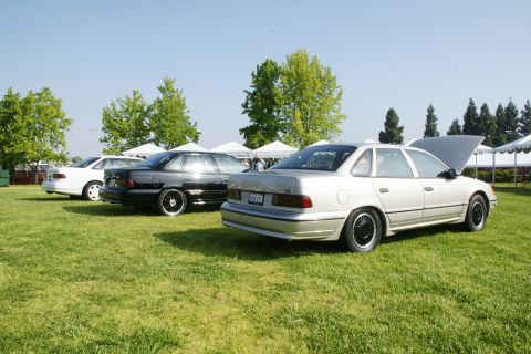 1992 Ford Taurus - A silver 1992 Ford Taurus sedan is displayed with its hood open at an outdoor car show.