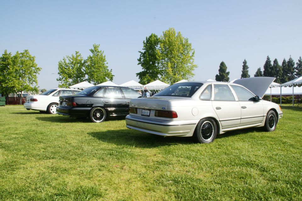Silver 1992 Ford Taurus sedan, hood open, parked on grass