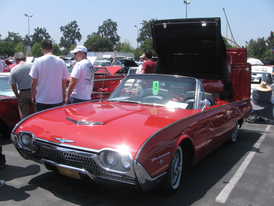 Red 1961 Ford Thunderbird convertible with top up. Thunderbird script visible on fender