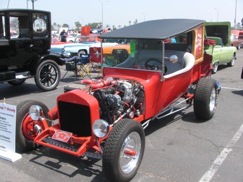 1996 Ford C-350 (Centurion Conversions) - Red hot rod with exposed engine and black soft top, parked at an outdoor event with other vehicles.