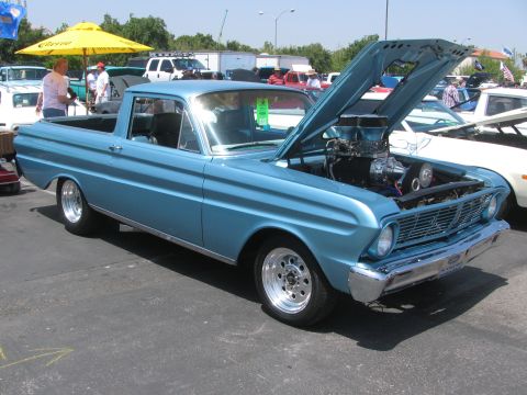 1996 Ford C-350 (Centurion Conversions) - A light blue pickup truck with its hood open, revealing a large engine, sits in a parking lot with other vehicles.