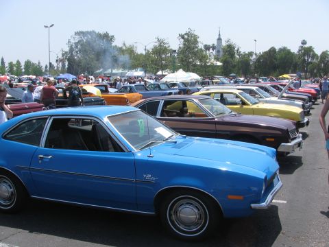 1996 Ford C-350 (Centurion Conversions) - Blue Ford Pinto coupe at a car show with other vehicles lined up.