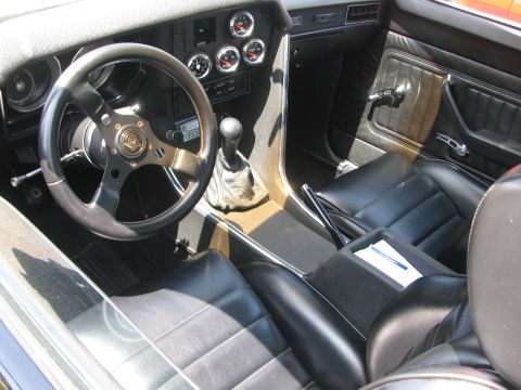 1996 Ford C-350 (Centurion Conversions) - The interior of a custom van features black leather seats and a dashboard with several gauges.