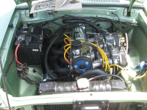 1996 Ford C-350 (Centurion Conversions) - The engine bay of a classic vehicle, a chrome valve cover and dual carburetors.
