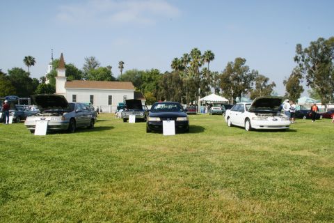 1992 Ford Taurus - Several cars are displayed on a grassy field in front of a white building with a steeple.