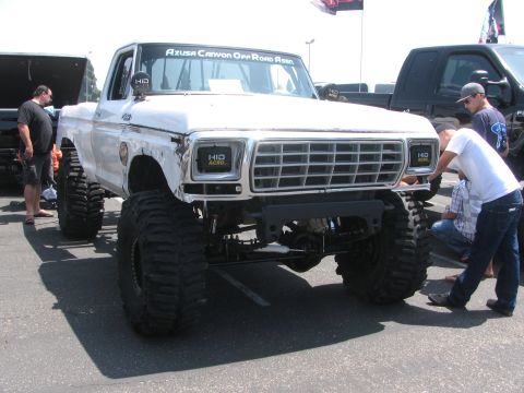 1996 Ford C-350 (Centurion Conversions) - Modified 1979 Ford pickup truck with oversized tires and custom front end is parked outdoors.