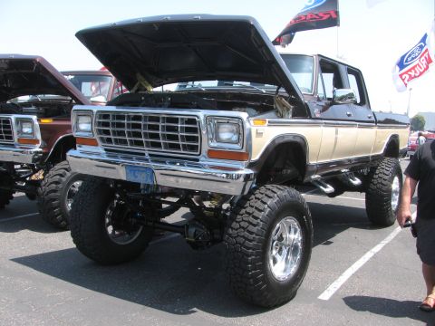 1996 Ford C-350 (Centurion Conversions) - This lifted Ford pickup truck, likely from the late 1970s, is parked next to another similar vehicle.