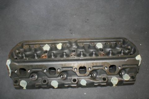 1994 Ford Bronco - A cast iron engine cylinder head is shown against a dark background.
