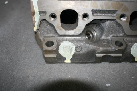 1994 Ford Bronco - A close-up view of a metal engine cylinder head, showing its internal structure and some white markings.