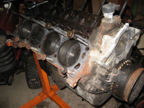 1994 Ford Bronco - Engine block on a stand, with visible cylinders and valve train components, showing signs of wear and rust.