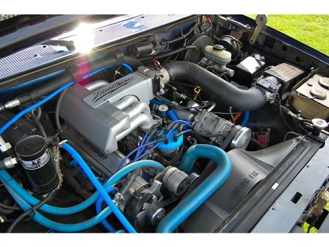1994 Ford Bronco - Close-up of an engine bay, showing a "LIGHTNING" intake manifold and blue hoses.