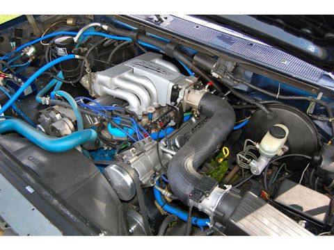 1994 Ford Bronco - Close-up view of an engine bay blue hoses, a silver intake manifold, and a black air intake hose with 'Motorsport' branding.