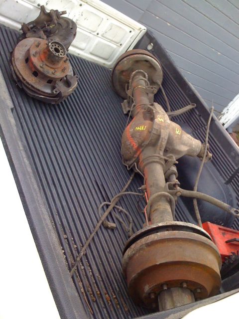 1989 Ford Bronco - Front and rear axles from a Ford Bronco are loaded in the bed of a pickup truck.