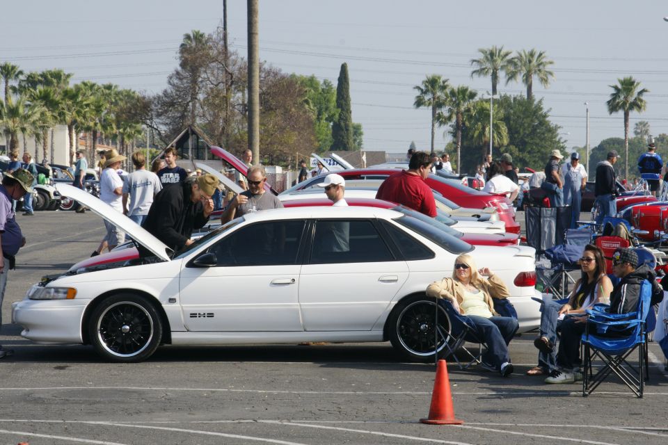 White sedan with hood open, black rims, and "24V" badge on the side