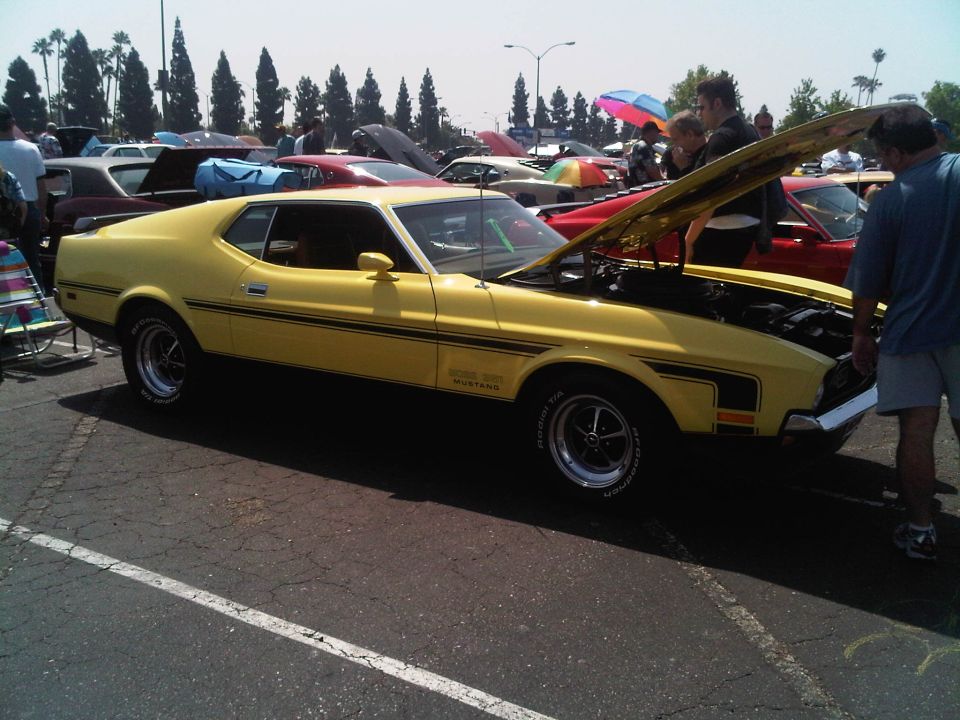 Yellow 1971 Ford Mustang Mach 1 with hood open at a car show