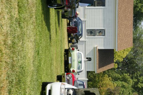1992 Ford Taurus - A light green 1957 Ford Thunderbird is parked on a grassy lawn next to a white building.