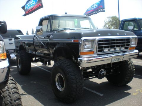 1979 Ford Bronco - A black Ford pickup truck with custom modifications is parked in a lot, with other vehicles visible.