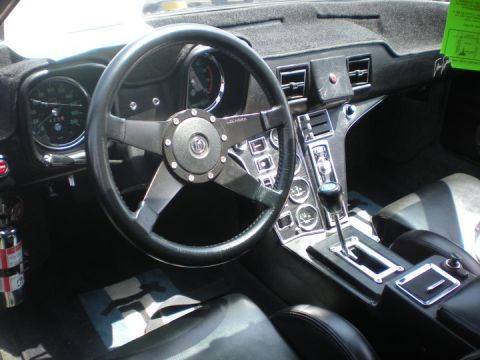 1979 Ford Bronco - The interior of a classic car features a steering wheel, dashboard gauges, and a center console with a gear shifter.