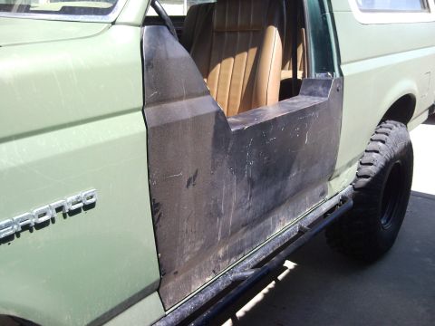 1989 Ford Bronco - Side view of a 1989 Ford Bronco, showing its tan interior and custom doors.