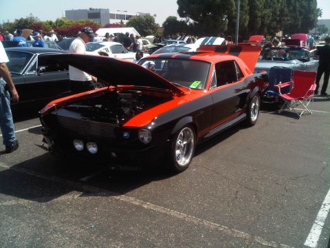 1986 Ford Bronco - Two-tone 1967 Ford Mustang displayed with its hood up at an outdoor car event.