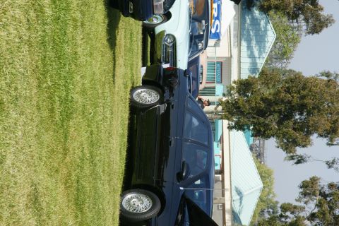 1992 Ford Taurus - Several cars are parked on a grassy area in front of buildings.