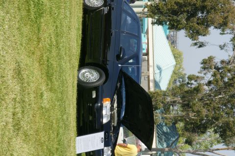 1992 Ford Taurus - A black 1992 Ford Taurus sedan is displayed with its hood open on a grassy lawn.