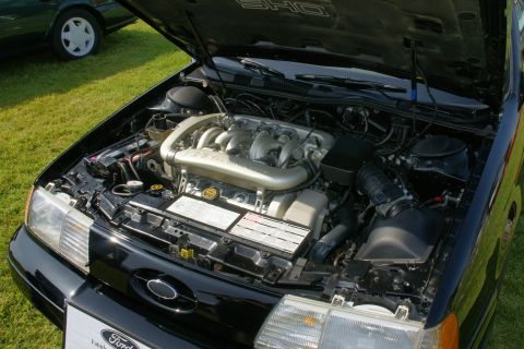 1992 Ford Taurus - The engine bay of a black Ford Taurus SHO is displayed with the hood open.