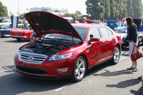 1992 Ford Taurus - A red sedan, likely a Ford Taurus from the 2010 model year, is displayed with its hood open at an outdoor car show.