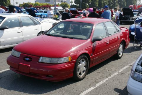 1992 Ford Taurus - A red 1992 Ford Taurus sedan is displayed at a car show event.