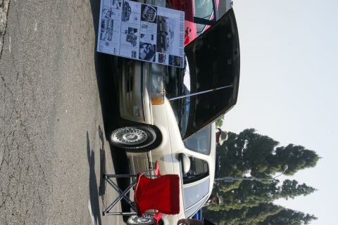 1992 Ford Taurus - A beige sedan is displayed with its hood open, revealing a poster detailing information about the vehicle.