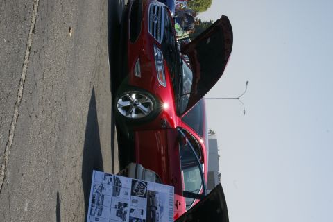 1992 Ford Taurus - A red sedan is displayed with its hood open, showing the engine compartment. A display board is placed in front of the vehicle.
