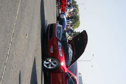 1992 Ford Taurus - A red sedan is parked with its hood open, showing a chrome grille and headlights.