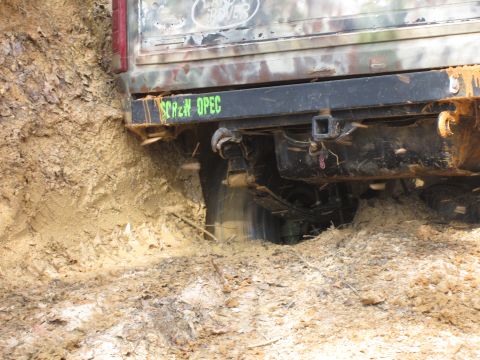 1993 Ford Bronco - Off-road vehicle with custom bumper text gets stuck deep in mud.