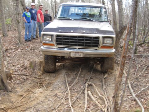 1993 Ford Bronco - This Ford truck is navigating a rough, wooded trail with several people watching.