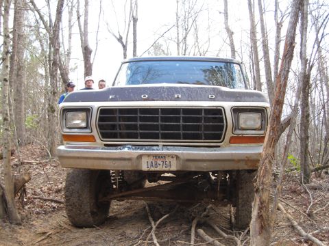 1993 Ford Bronco - This lifted Ford truck is seen from the front in a wooded area, with a Texas license plate visible.