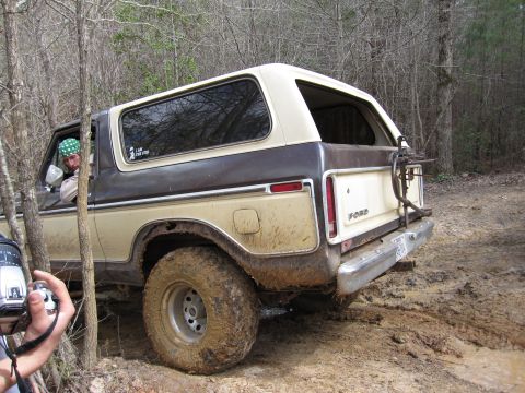 1993 Ford Bronco - This second-generation Ford Bronco, likely from the late 1970s, navigates a muddy off-road trail.