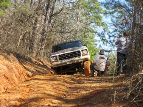 1993 Ford Bronco - Ford Bronco navigating a challenging off-road trail with onlookers present.