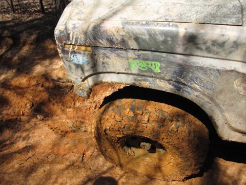 1993 Ford Bronco - This vehicle is covered in mud and appears to be stuck in a muddy terrain.