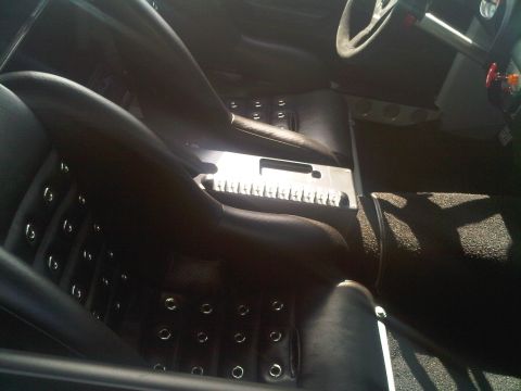 1986 Ford Bronco - Interior view of a vehicle with black leather seats and a metal center console.