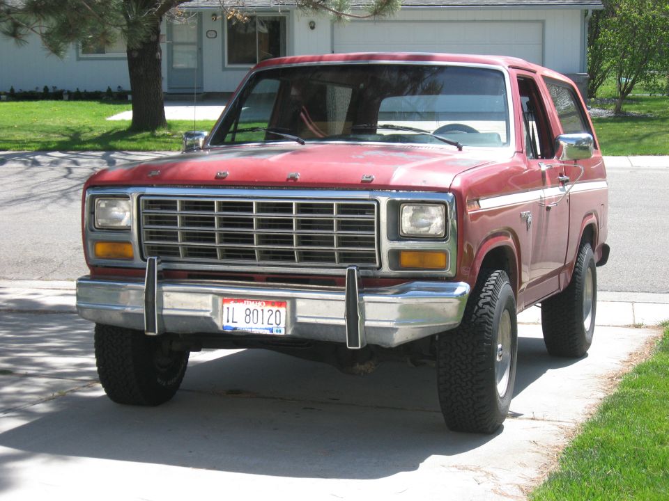 Red 1981 Ford Bronco front view with chrome grille and license plate IL 80120