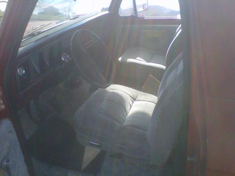 1978 Ford Bronco - The interior of the vehicle shows the dashboard, steering wheel, and front seats with a distinctive plaid upholstery pattern.